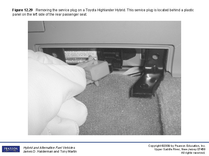 Figure 12. 29 Removing the service plug on a Toyota Highlander Hybrid. This service