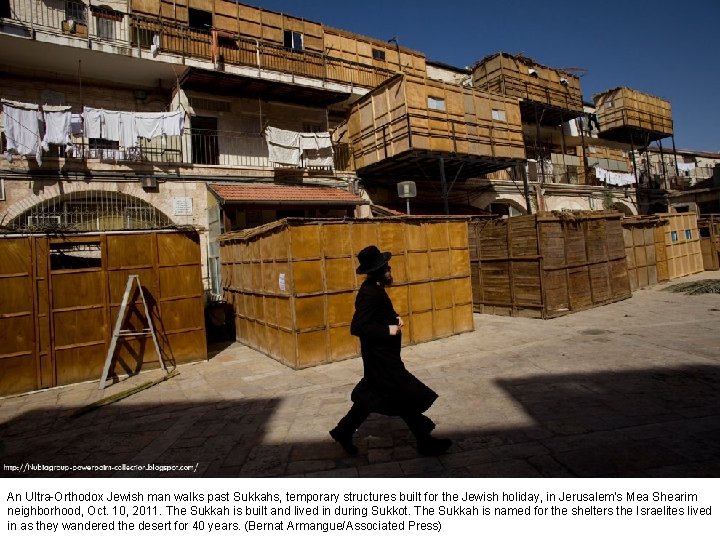 An Ultra-Orthodox Jewish man walks past Sukkahs, temporary structures built for the Jewish holiday,