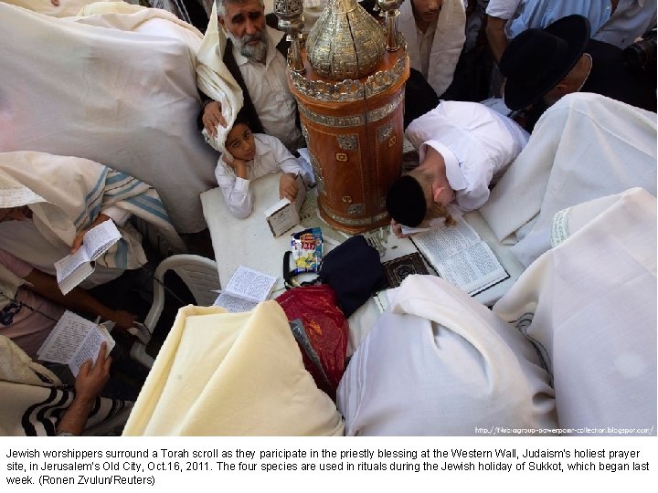 Jewish worshippers surround a Torah scroll as they paricipate in the priestly blessing at