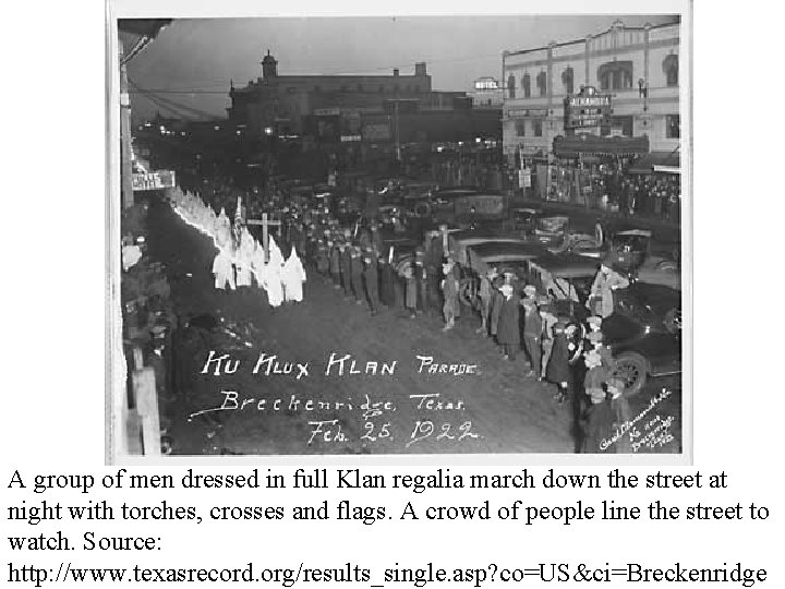A group of men dressed in full Klan regalia march down the street at A group of men dressed in full Klan regalia march down the street at