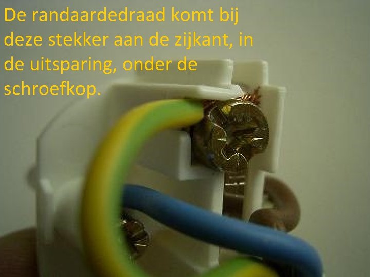 De randaardedraad komt bij deze stekker aan de zijkant, in de uitsparing, onder de