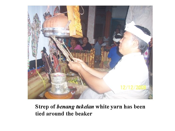 Strep of benang tukelan white yarn has been tied around the beaker 