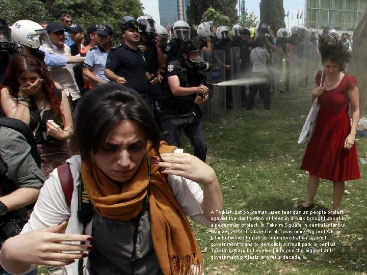 A Turkish riot policeman uses tear gas as people protest against the destruction of