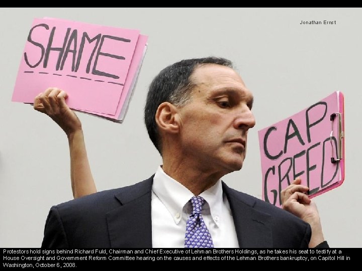 Jonathan Ernst Protestors hold signs behind Richard Fuld, Chairman and Chief Executive of Lehman