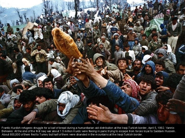 Frantic Kurdish refugees struggle for a loaf of bread during a humanitarian aid distribution