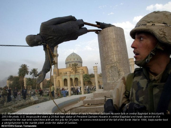 U. S. Marine Corp Assaultman Kirk Dalrymple watches as a statue of Iraq's President