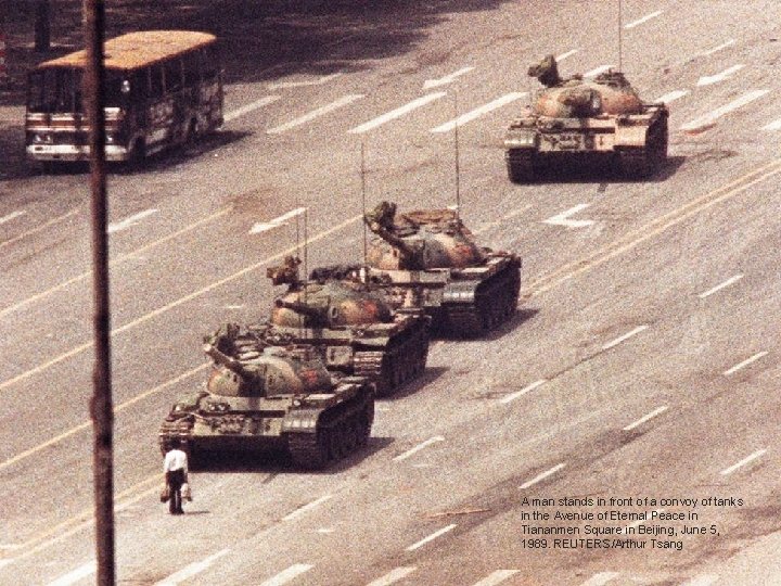 A man stands in front of a convoy of tanks in the Avenue of