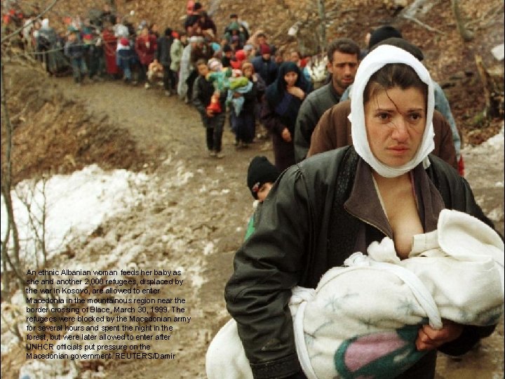 An ethnic Albanian woman feeds her baby as she and another 2, 000 refugees,