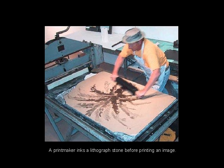A printmaker inks a lithograph stone before printing an image. 