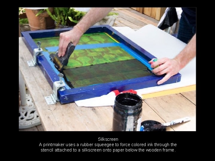 Silkscreen A printmaker uses a rubber squeegee to force colored ink through the stencil