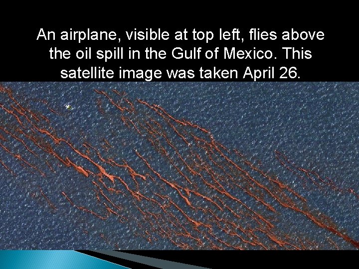 An airplane, visible at top left, flies above the oil spill in the Gulf