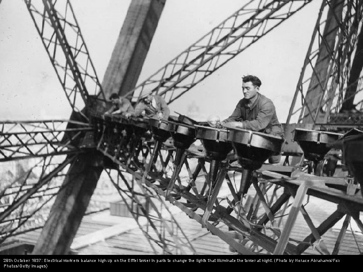 29 th October 1937: Electrical workers balance high up on the Eiffel tower in