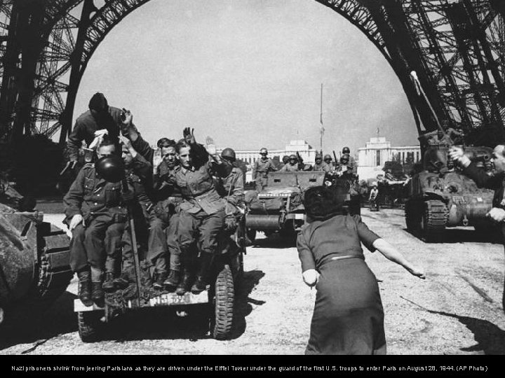 Nazi prisoners shrink from jeering Parisians as they are driven under the Eiffel Tower