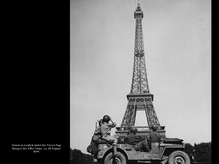 American soldiers watch the French flag flying on the Eiffel Tower, ca. 25 August