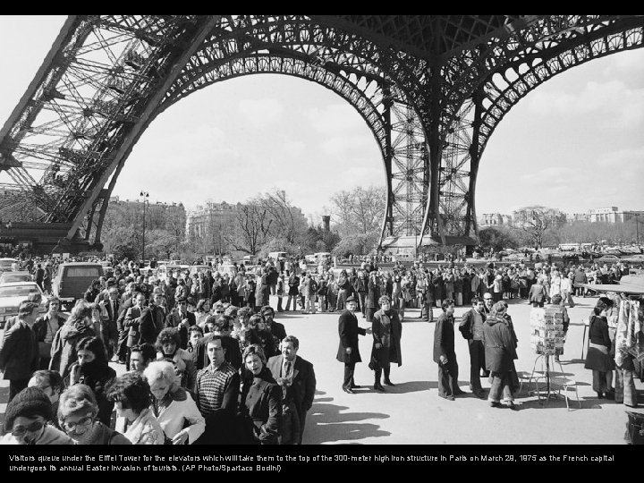 Visitors queue under the Eiffel Tower for the elevators which will take them to