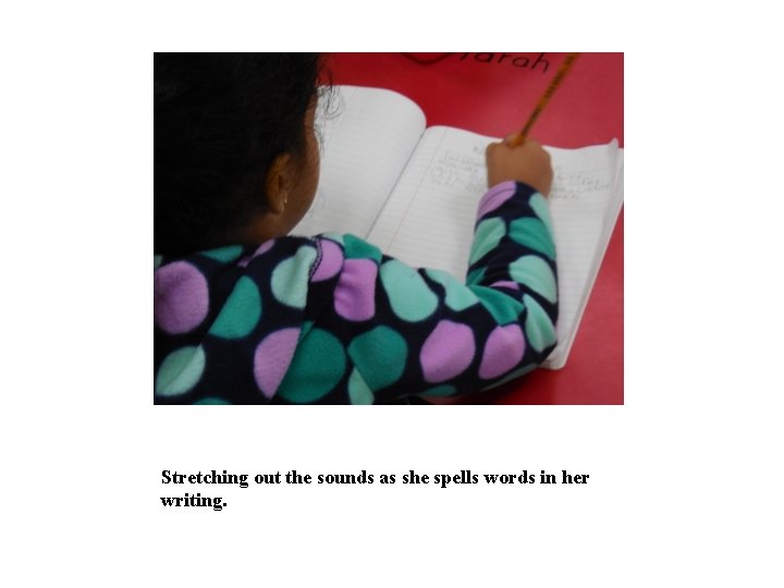 Stretching out the sounds as she spells words in her writing. 