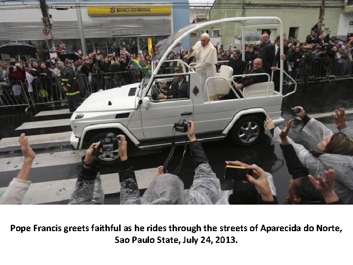 Pope Francis greets faithful as he rides through the streets of Aparecida do Norte,