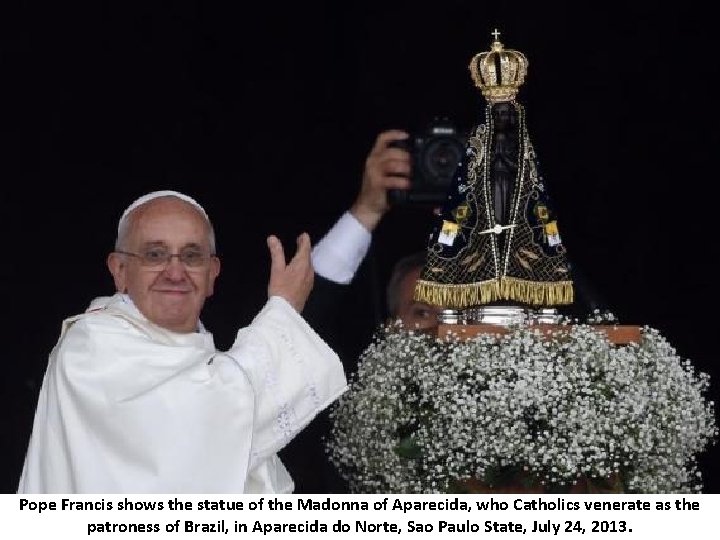 Pope Francis shows the statue of the Madonna of Aparecida, who Catholics venerate as