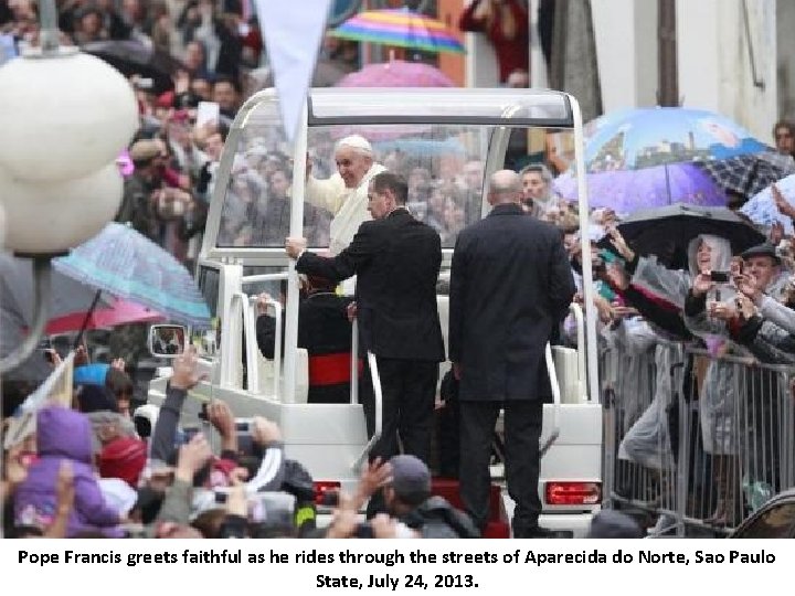 Pope Francis greets faithful as he rides through the streets of Aparecida do Norte,