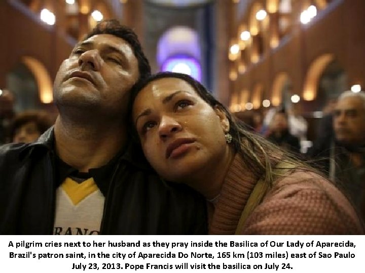 A pilgrim cries next to her husband as they pray inside the Basilica of