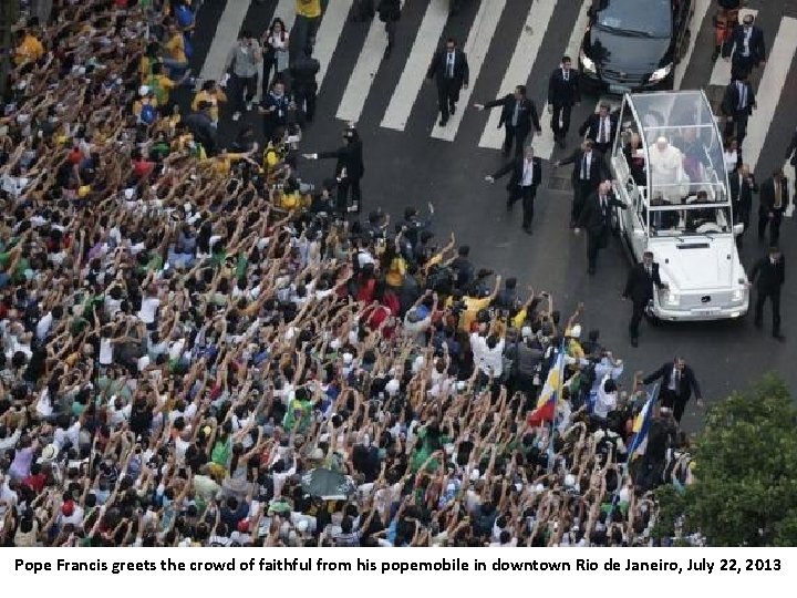 Pope Francis greets the crowd of faithful from his popemobile in downtown Rio de