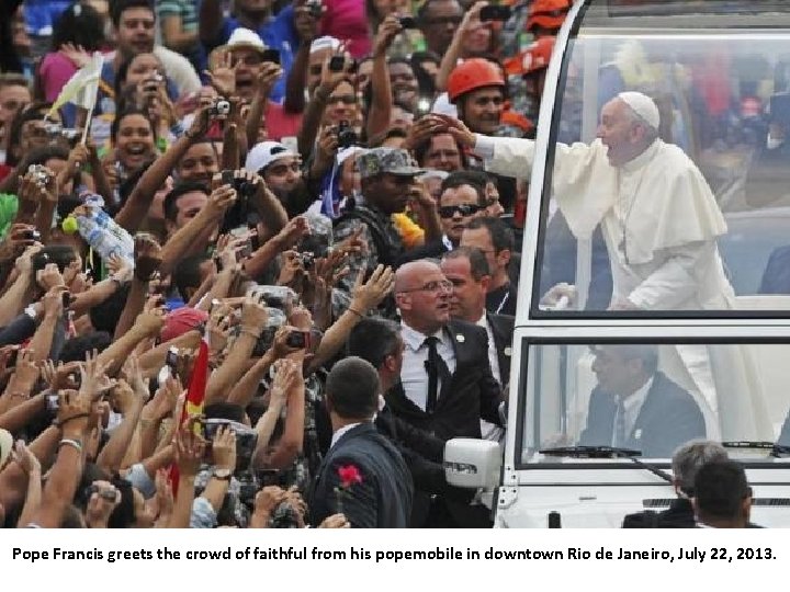 Pope Francis greets the crowd of faithful from his popemobile in downtown Rio de