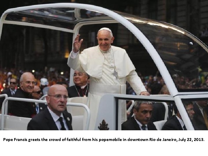 Pope Francis greets the crowd of faithful from his popemobile in downtown Rio de