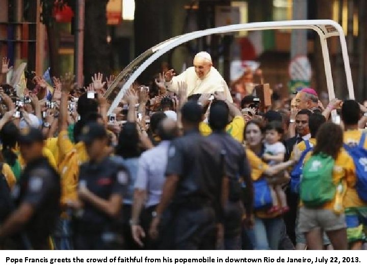 Pope Francis greets the crowd of faithful from his popemobile in downtown Rio de