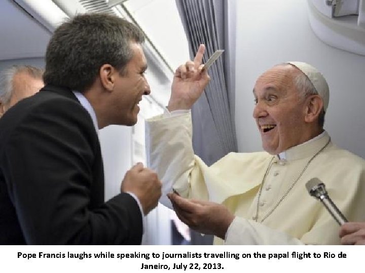 Pope Francis laughs while speaking to journalists travelling on the papal flight to Rio