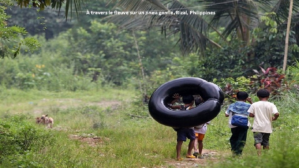 À travers le fleuve sur un pneu gonflé. Rizal, Philippines 