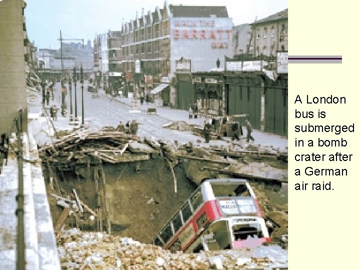 A London bus is submerged in a bomb crater after a German air raid.