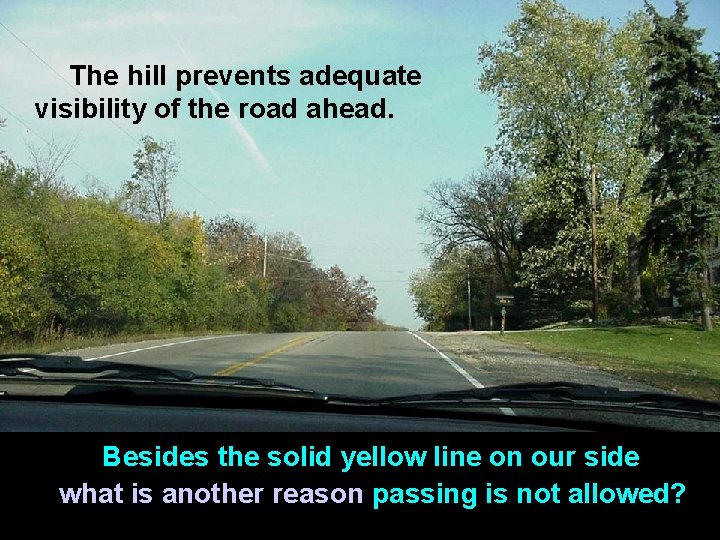 The hill prevents adequate visibility of the road ahead. Besides the solid yellow line
