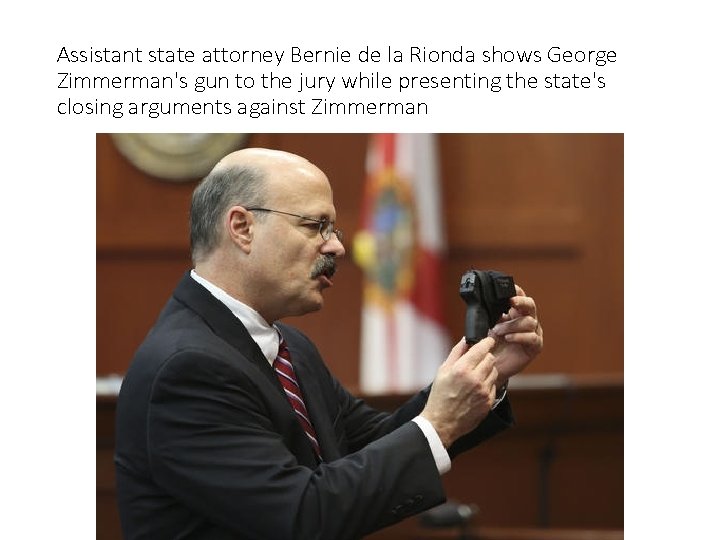 Assistant state attorney Bernie de la Rionda shows George Zimmerman's gun to the jury