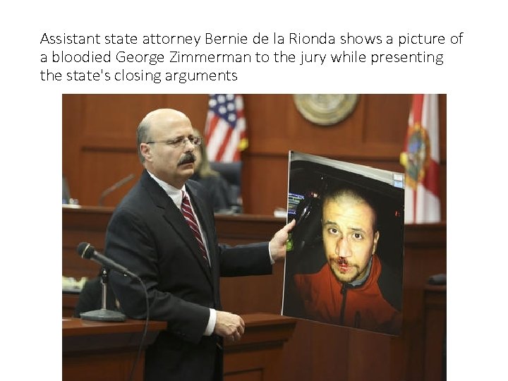 Assistant state attorney Bernie de la Rionda shows a picture of a bloodied George