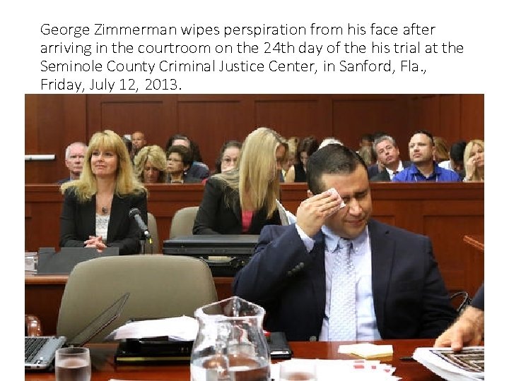 George Zimmerman wipes perspiration from his face after arriving in the courtroom on the