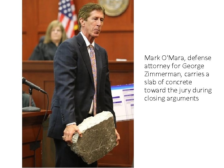 Mark O'Mara, defense attorney for George Zimmerman, carries a slab of concrete toward the