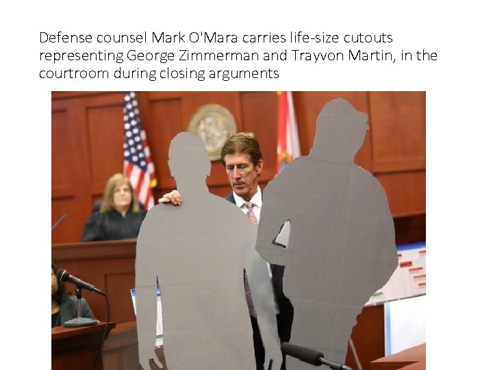 Defense counsel Mark O'Mara carries life-size cutouts representing George Zimmerman and Trayvon Martin, in
