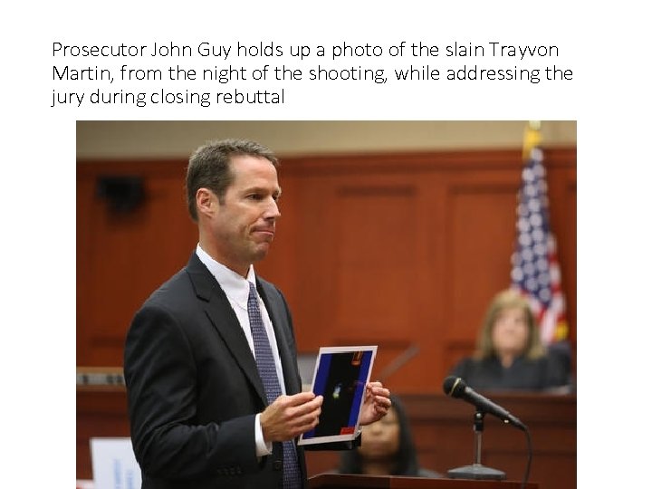 Prosecutor John Guy holds up a photo of the slain Trayvon Martin, from the