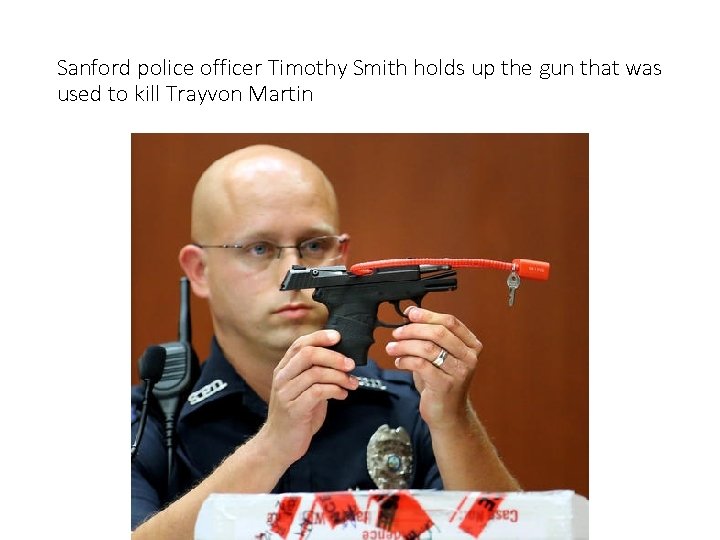 Sanford police officer Timothy Smith holds up the gun that was used to kill