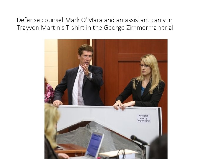 Defense counsel Mark O'Mara and an assistant carry in Trayvon Martin's T-shirt in the