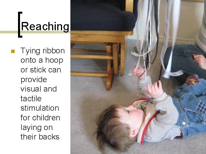 Reaching n Tying ribbon onto a hoop or stick can provide visual and tactile