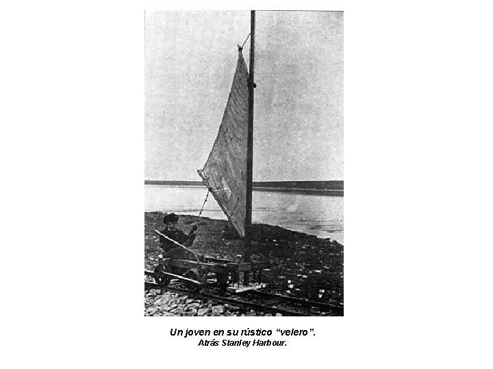 Un joven en su rústico “velero”. Atrás Stanley Harbour. 