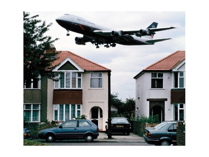 Suburban homes with an airplane taking off in the background implying they live close Suburban homes with an airplane taking off in the background implying they live close
