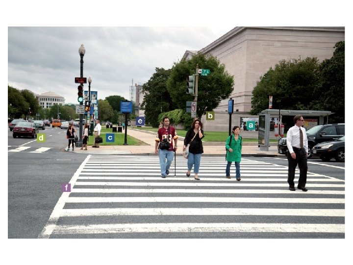 A city intersection with people crossing the street heading towards the foreground with letters A city intersection with people crossing the street heading towards the foreground with letters