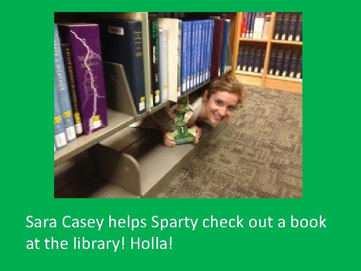 Sara Casey helps Sparty check out a book at the library! Holla! 