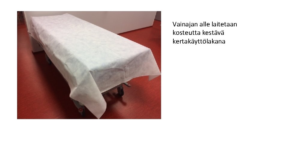 Vainajan alle laitetaan kosteutta kestävä kertakäyttölakana Vainajan alle laitetaan kosteutta kestävä kertakäyttölakana