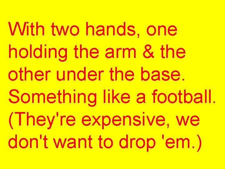 With two hands, one holding the arm & the other under the base. Something