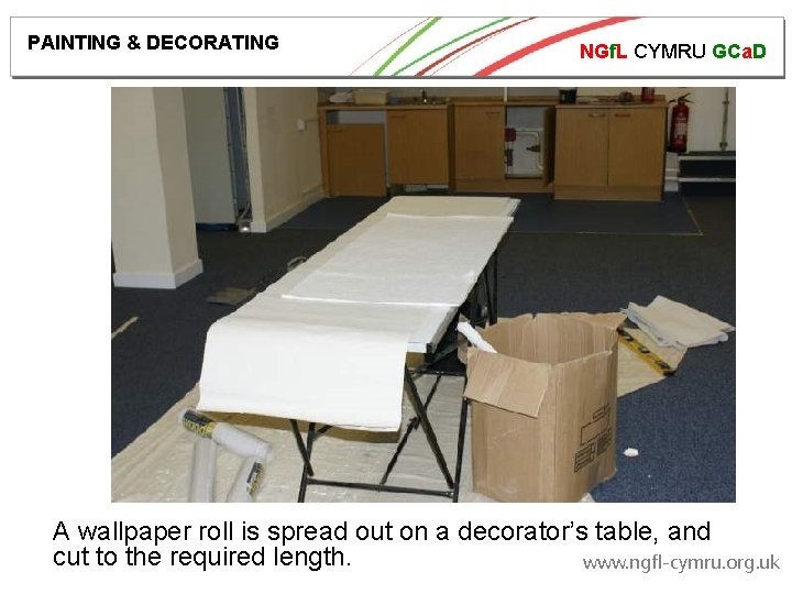PAINTING & DECORATING NGf. L CYMRU GCa. D A wallpaper roll is spread out