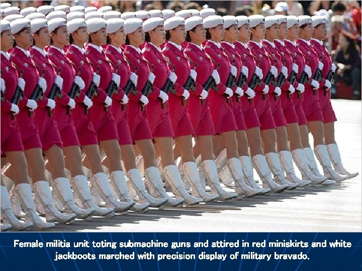Female militia unit toting submachine guns and attired in red miniskirts and white jackboots