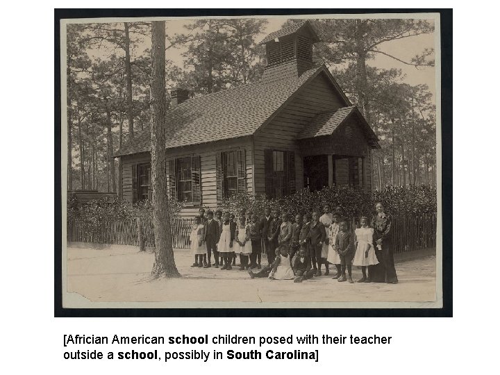 [Africian American school children posed with their teacher outside a school, possibly in South